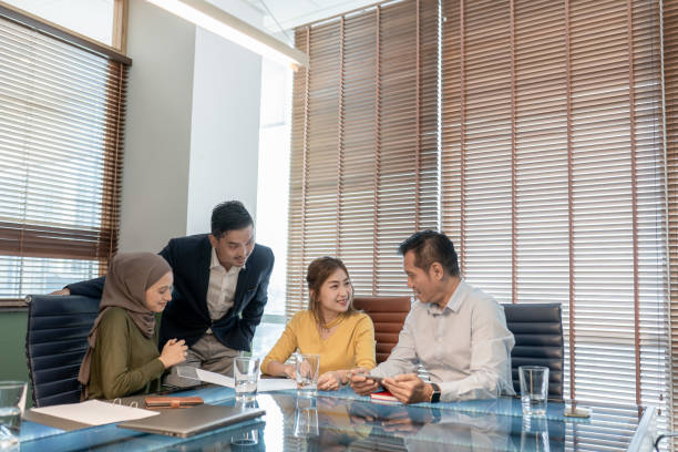 asian businesspeople discussing sitting at desk in modern office. - 会议 個照片及圖片檔